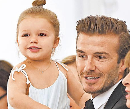 贝克汉姆女儿绑丸子头 坐老爸腿上扭来扭去(图